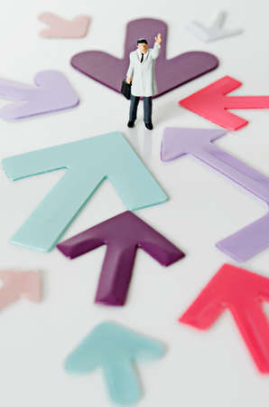 Business Figurine with arm raised with arrowsの写真素材