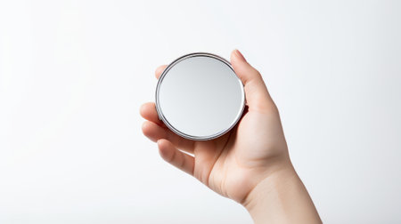 a hand holding a small, round mirror that reflects a burst of white light, set against a minimalist backdrop AI generatedの素材