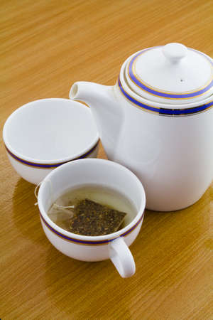 Cup of tea and teapot on the wood tableの写真素材