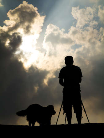 Silhouette photographer and his dogの写真素材