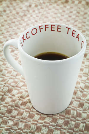 Cup of coffee on weaved clothの写真素材