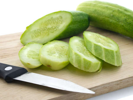 Cucumbers and knife on chopping boardの写真素材