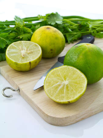 Sliced lime and parsley on chopping boardの写真素材