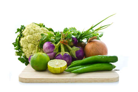 Various kinds of vegetable on chopping board isolated on whiteの写真素材