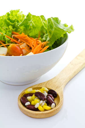 Cereal on wooden spoon with bowl of saladの写真素材