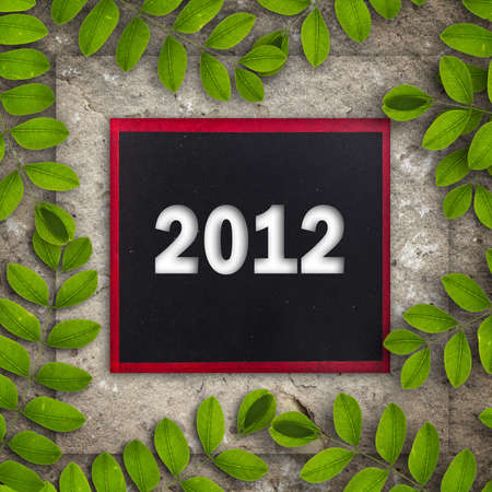 2012 on blackboard on stone wall with creeper leaves