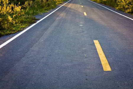 Closeup of asphalt suburban road with sunlightの写真素材