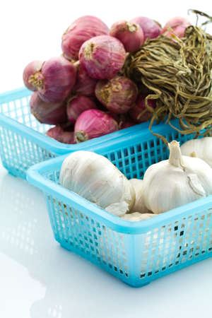 Garlic and red onion in plastic basketの写真素材