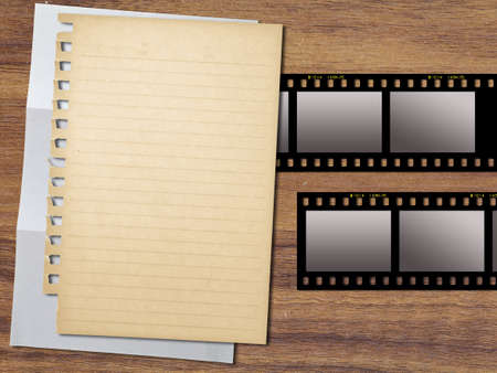 Yellowed paper and filmstrips on wood backgroundの写真素材