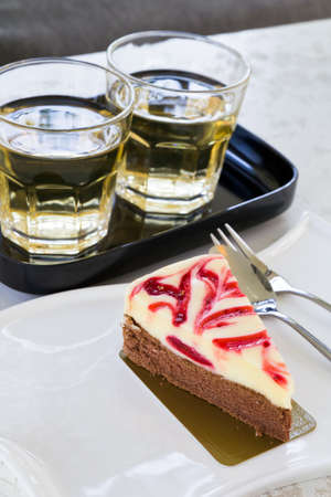 Strawberry cheese cake on white plate with glasses of teaの写真素材