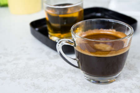 Cup of coffee on wood table with tea on backgroundの写真素材