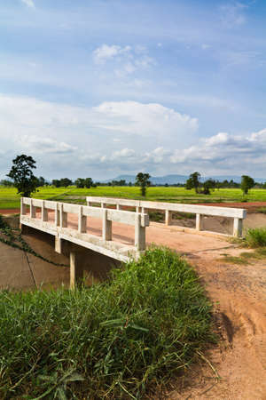 White bridge over irrigation canal in farmlandの写真素材