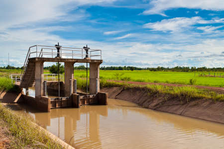 Sluice on irrigation canal in farmlandの写真素材