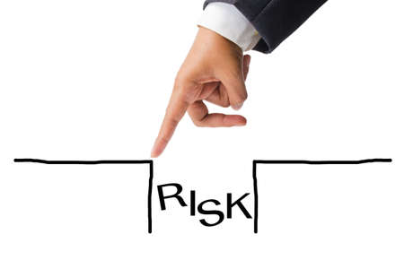 Business hand as finger jumping over the risk holeの写真素材
