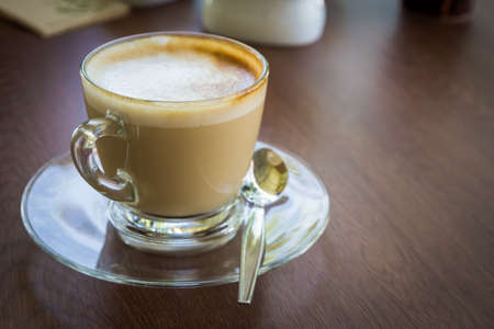 Cappuccino in glass cup on wood table