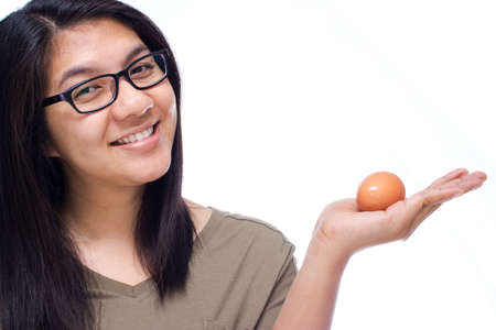 Woman smiling with raw egg in handの写真素材