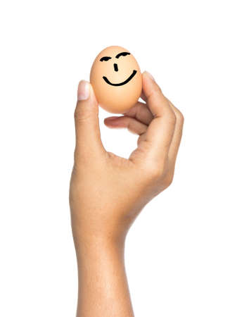 Hand show smiling raw egg for happy nutrition concept