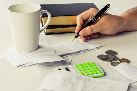 Hand calculating bills on the desk