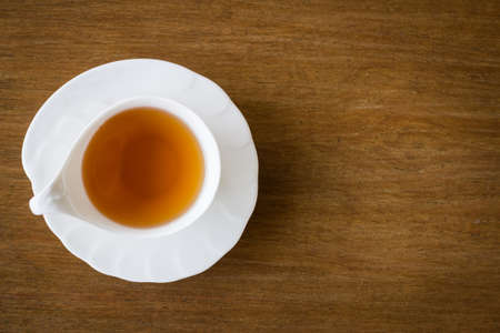 White cup of tea on wood background, top viewの写真素材