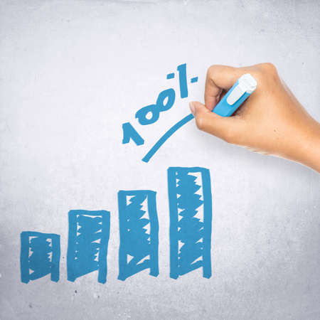 Hand writing one-hundred percent graph on gray backgroundの写真素材