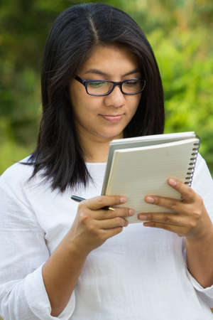 Female student reading lecture in the park
