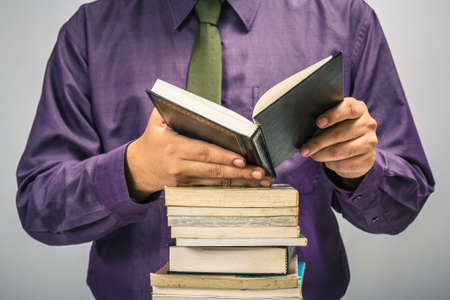 Man reading on stack of used book