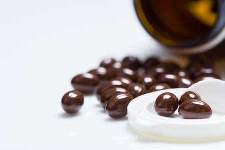 Vitamin pills with bottle and part of water on white backgroundの写真素材