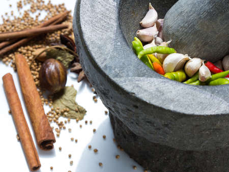 Fresh chili and garlic (Basic Thai ingredients) in mortar with spices on the tableの写真素材