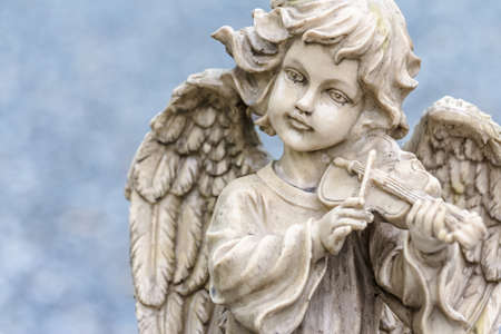 Old cupid statue playing violin in the parkの写真素材