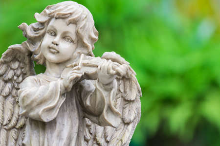 Old cupid statue playing violin in the parkの写真素材