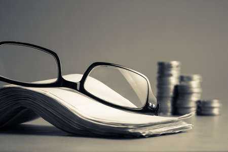 Eyeglasses and pile of bills for accountancy calculation conceptの写真素材