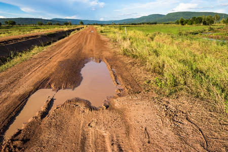 Soil road with muddy tracks in countrysideの写真素材