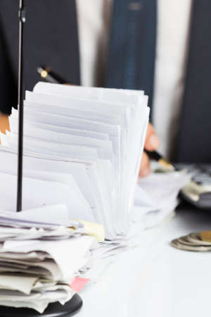 A lot of receipts in paper nail with accountant working on backgroundの写真素材