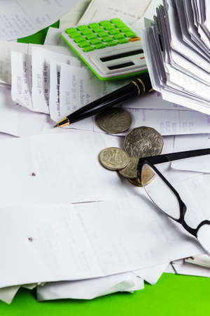 Many receipts to work with coins, pen, glasses and calculatorの写真素材