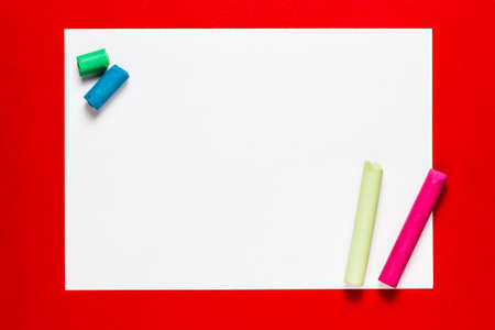 Paper on red background with color pastel sticksの写真素材
