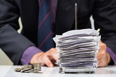 Businessman working with bills in paper nailの写真素材