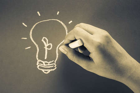 Hand drawing light bulb with chalk, idea for business conceptの写真素材
