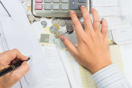 Closeup hand working  with receipts on the deskの写真素材
