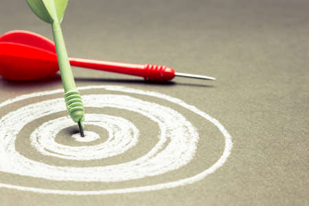 Dart hit on the center of sketching dartboard with copy spaceの写真素材