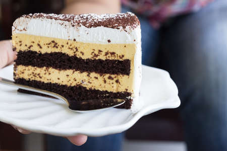 Butter and caramel cake with chocolate chips topping in handの写真素材