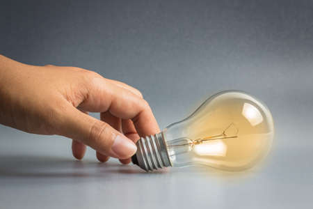 Hand taking light bulb as idea symbolの写真素材