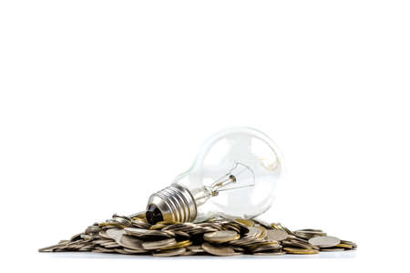 Light bulb on pile of coins isolated on white for financial plan or business idea conceptの写真素材