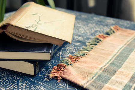 Old books on table cloth in retro color style