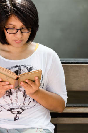 Woman in casual clothes reading old bookの写真素材