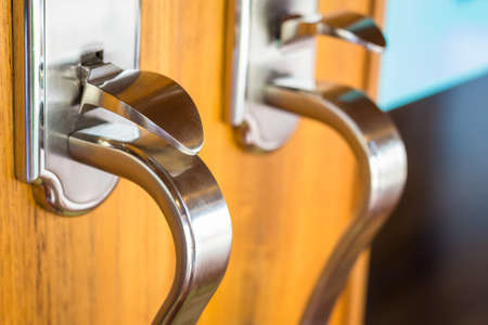 Closeup modern steel knob on wood doorの写真素材