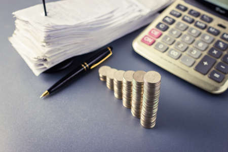 Coins heap stair as growing graph symbol on finance working desk