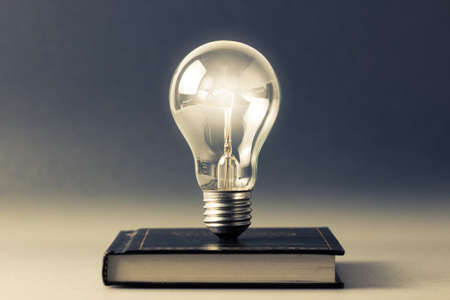 Light bulb glowing on a hardcover book