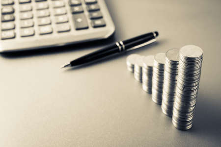 Coins heap stair as growing graph symbol on finance working deskの写真素材