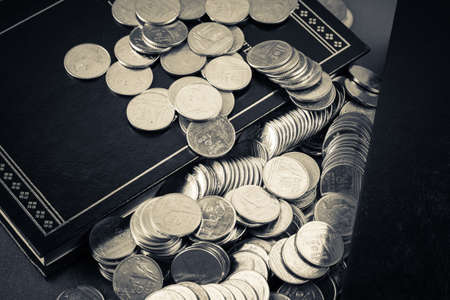 Coins heap on the book as business learning conceptの写真素材