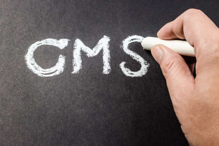 Hand writing CMS abbreviation (content management system) with chalkの写真素材